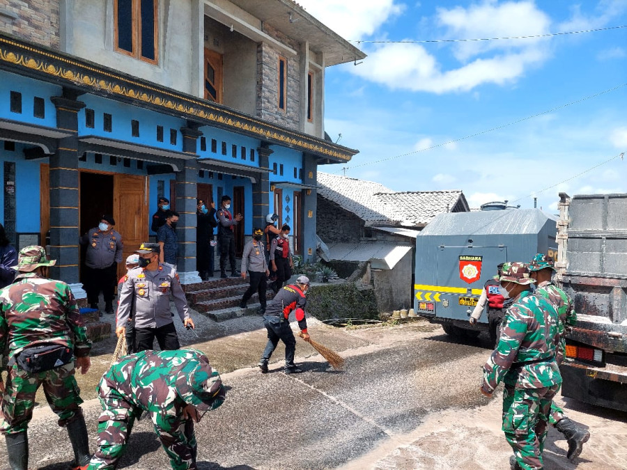 Polisi Kerahkan Personil Membantu Masyarakat Bersihkan Abu Vulkanik di Jalan
