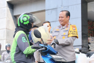 Polda Metro Jaya Bagikan Helm dan Sembako Kepada Masyarakat
